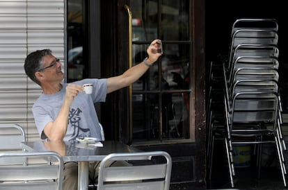 Un hombre se fotografía tomando un café en el bar Zúrich de Barcelona.