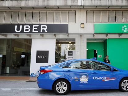 Un taxi ComfortDelgro pasa por delante de oficinas de Uber y Grab en Singapur.