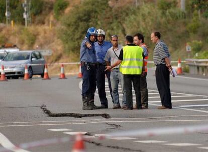 Agentes y técnicos observan una grieta en la C-55 a su paso por Olesa de Montserrat (Barcelona).