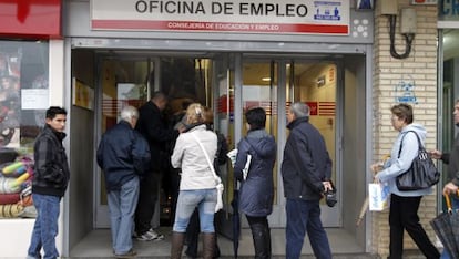 People wait in line at an unemployment office in Madrid's Santa Eugenia district.