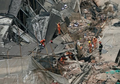 Los bomberos trabajan en la zona del derrumbe de un edificio en Shanghai (China). 