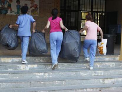 Operarias recogen la basura de un colegio de Jerez. 