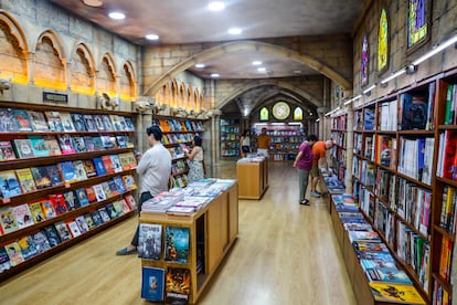 Clientes de Akira cómics, en Madrid, observan el lunes 4 de agosto tebeos en la parte de la tienda dedicada a obras europeas, que evoca una catedral. 