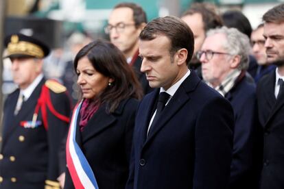 La alcaldesa de París, Anne Hidalgo, y el presidente galo, Emmanuel Macron, guardan silencio delante del bar "Comptoir Voltaire" en memoria de las víctimas de los atentados de París (Francia) del 13 de noviembre de 2015, que dejaron 130 muertos.