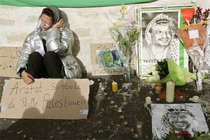 Una mujer sostiene un cartel en el que se lee "Arafat: símbolo del pueblo palestino" en el hospital militar de Percy, a las afueras de París.
