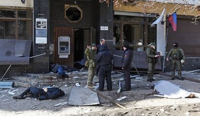Policías y miembros prorrusos junto a los cuerpos de varios civiles tras un bombardeo en la ciudad de Donetsk, este lunes.
