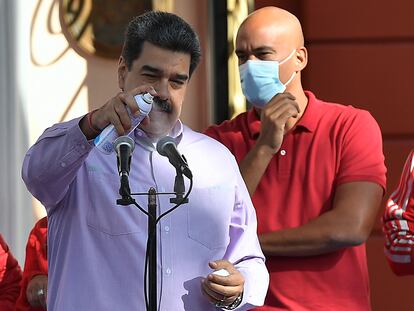 Nicolás Maduro desinfecta un micrófono durante un evento en Caracas, este domingo.