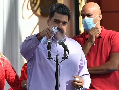 Nicolás Maduro desinfecta un micrófono durante un evento en Caracas, este domingo.