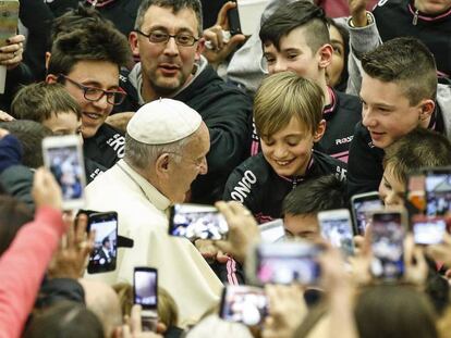 El papa Francisco saluda a unos j&oacute;venes a su llegada al aula Pablo VI en el Vaticano.