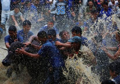 Un grupo de gente salpica agua a un búfalo para prepararlo para el sacrificio durante el "Dashain", el festival religioso más importante del hinduísmo en Bhaktapur (Nepal).