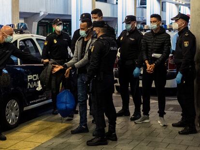 Dos jóvenes migrantes marroquíes esposados llegan al aeropuerto de Las Palmas, Canarias para ser deportados por la policía, en diciembre 2020.