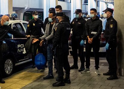 Dos jóvenes migrantes marroquíes esposados llegan al aeropuerto de Las Palmas (Gran Canaria) para ser deportados por la Policía, en diciembre de 2020.