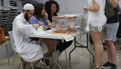 David Franco Portolés checks ID cards at a polling station.