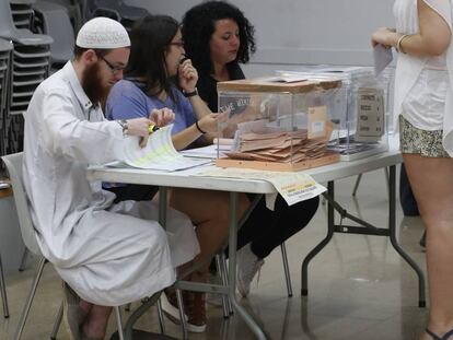 David Franco Portolés checks ID cards at a polling station.