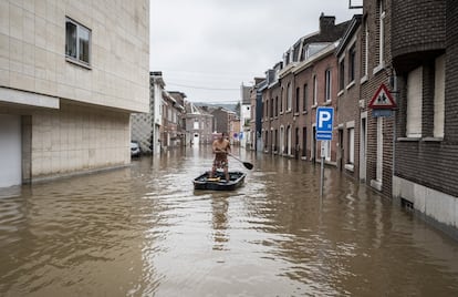 Un hombre navega en un bote por una calle residencial inundada en Angleur, provincia de Lieja, Bélgica, el viernes 16 de julio de 2021.