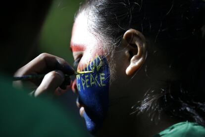 In this Nov. 23, 2016 photo, a woman New People's Army guerrilla who uses the nom de guerre Comrade May has her face painted to conceal her identity as reporters visit their rebel encampment tucked in the harsh wilderness of the Sierra Madre mountains, southeast of Manila, Philippines. Young Filipino rebels represent a new generation of Maoist fighters, who reflect the resiliency and constraints of an insurgency that has dragged on for nearly half a century through six Philippine presidencies. Crushing poverty, despair, government misrule and the abysmal inequality that has long plagued Philippine society were their best recruiter, according to the guerrillas. (AP Photo/Aaron Favila)