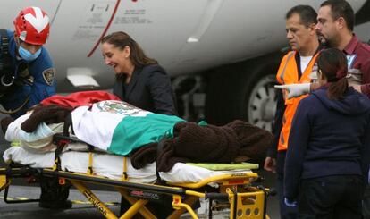 La secretaria de Relaciones Exteriores mexicana junto a un herido a su llegada al DF.