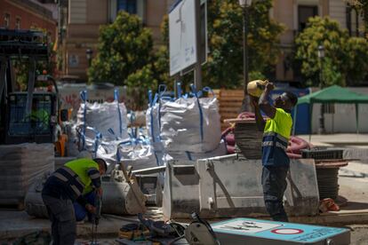 Operarios trabajan en una calle en el centro de Madrid, este lunes. 