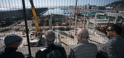 Un grupo de jubilados observan unas obras junto al puerto de Barcelona