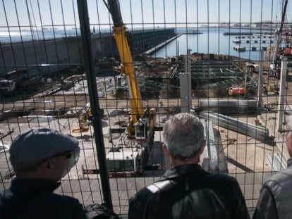 Un grupo de jubilados observan unas obras junto al puerto de Barcelona