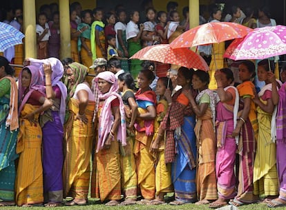 Mujeres indias hacen cola a la entrada de un centro electoral durante la tercera vuelta de las elecciones territoriales, en Baksa, Estado de Assam, India.