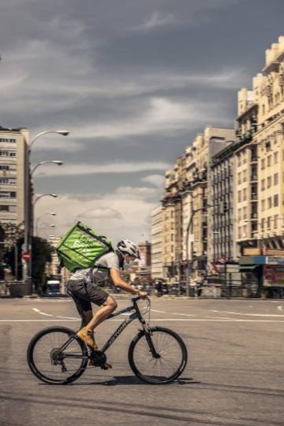 Un repartidor cicilista atraviesa Cuatro Caminos, Madrid.