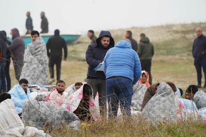 Varias personas atienden  a los supervivientes del naufragio de una embarcación de migrantes  que se ha producido frente a las costas de Calabria (sur de Italia) este domingo. 