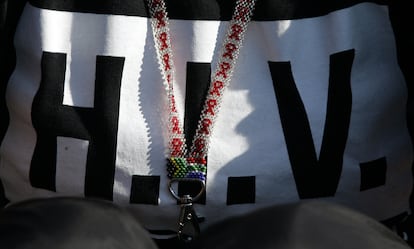 Un collar con la bandera sudafricana y una camiseta con la palabra "VIH" escrita en ella.