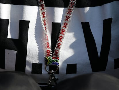 Un collar con la bandera sudafricana y una camiseta con la palabra "VIH" escrita en ella.