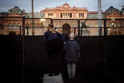 Two people protest on the fence that surrounds the Government House in Plaza de Mayo to ask for the release of the detainees.
