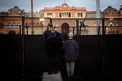 Dos personas protestan en el vallado que rodea la Casa de Gobierno  en Plaza de Mayo para pedir por la liberación de los detenidos.