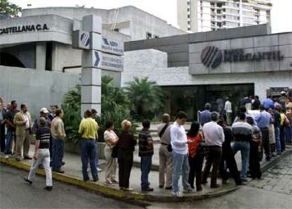 Los venezolanos acuden en tropel a retirar su dinero de los bancos, abiertos en horario restringido tras ocho días de huelga.