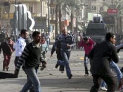 Manifestantes egipcios huyen de la policía durante una protesta en Suez