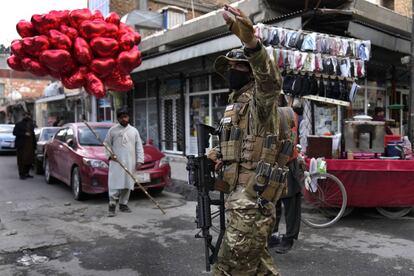 Un combatiente talibán dirige el tráfico mientras un vendedor ambulante vende globos rojos en forma de corazón para el Día de San Valentín, en Kabul (Afganistán).