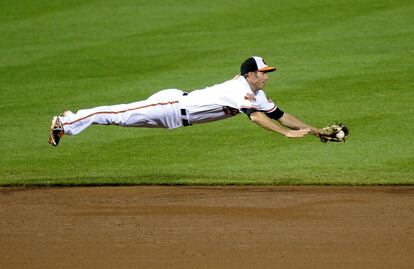 JJ Hardy del Baltimore Orioles atrapa la bola lanzada por un contrincante del Detroit Tigers durante un partido de béisbol en Baltimore. 12 de mayo de 2014.