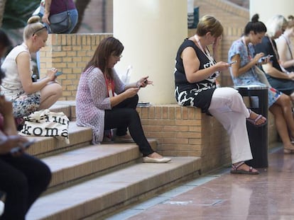 Un grupo de asistentes a un congreso en Sevilla usa sus dispositivos móviles conectados a la wifi del centro.