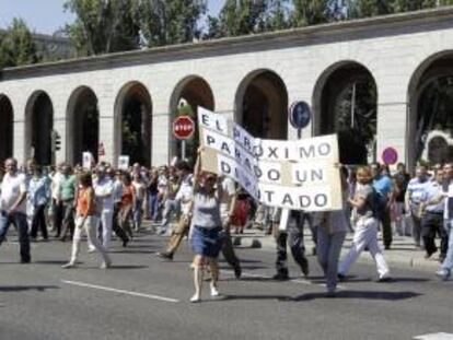Funcionarios públicos que trabajan en Nuevos Ministerios, en Madrid, cortan el tráfico este mediodía en el paseo de la Castellana en protesta por los nuevos ajustes aprobados por el Gobierno.