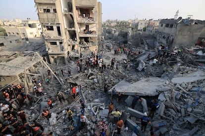 Decenas de palestinos buscaban supervivientes entre los escombros de varias casas destruidas por un bombardeo en el campo de refugiados de Al Magazi, en el centro de la Franja, este domingo.