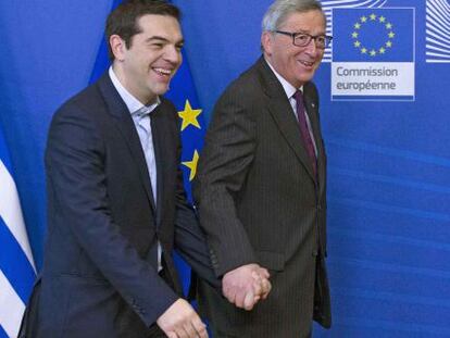 El presidente de la Comisión Europea, Jean-Claude Juncker, lleva de la mano al jefe de Gobierno griego, Alexis Tsipras, este miércoles en Bruselas.