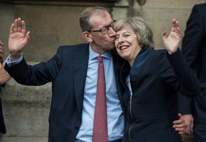 Theresa May junto a su marido John May, saluda a la prensa en la entrada del palacio de Westminster, el 11 de julio de 2016, tras ser nombrada primera ministra británica.