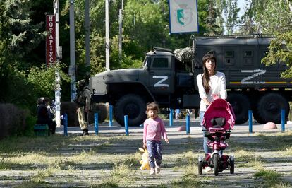Una mujer y una niña caminaban por un parque mientras patrullaban soldados rusos, el 20 de mayo en Skadovsk, en la provincia de Jersón.
