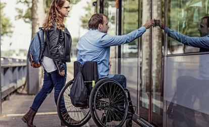 Un jove passeja en cadira de rodes amb la seva companya.
