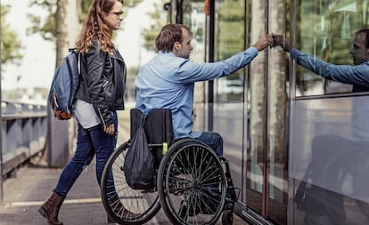 Un jove passeja en cadira de rodes amb la seva companya.