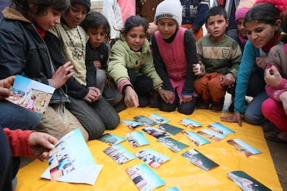 Varios niños observan las fotografías tomadas por sus compañeros y seleccionan sus preferidas. Retratarse les ayuda a conocerse, a sentir que son comunidad a pesar de haber llegado de muchos lugares distintos de Siria.