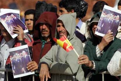 Varios marroquíes muestran en Marraquech fotos de Mohamed VI y Juan Carlos I durante la visita de este último, el 17 de enero de 2005.