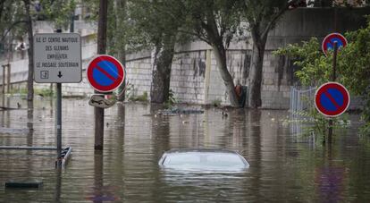 Un vehículo permanece sumergido a la orilla del río Sena en París.