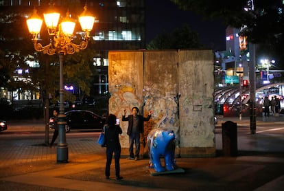 Una pareja se hace una foto delante de una parte del muro de Berlín expuesta en el parque de Berlín de Seúl (Cosera del Sur), el 17 de octubre de 2014.