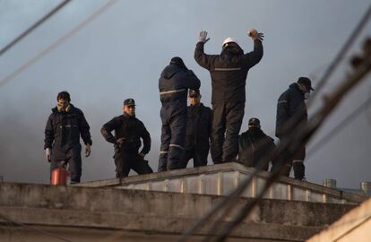 Efectivos de la policía y obreros negocian en la terraza de la planta.