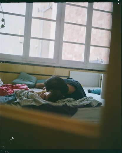 Un padre y su hija se abrazan sobre la cama.