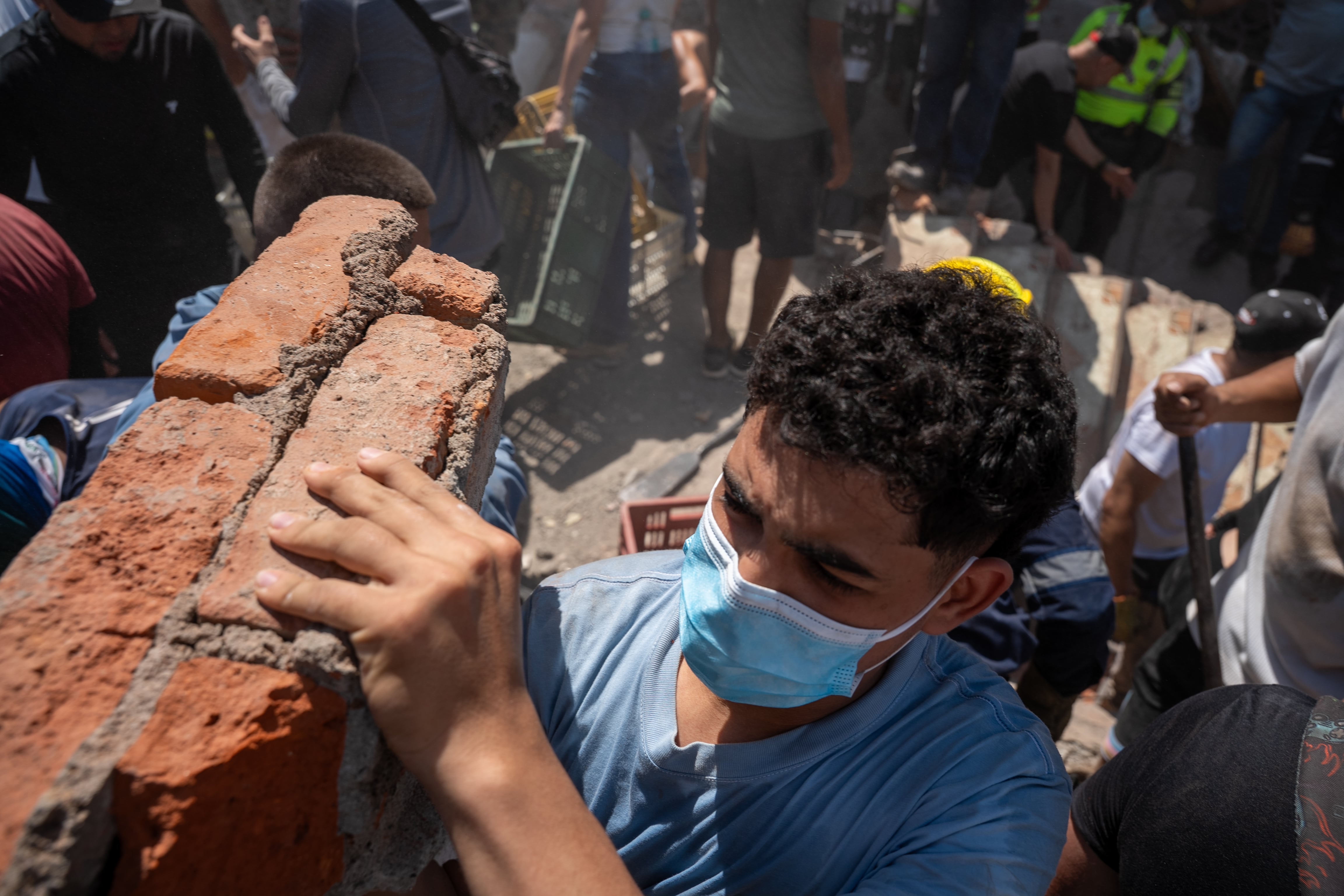 Voluntarios cargan escombros en una edificación colapsada por el temblor, en el Barrio Alameda, en Cali, Colombia.